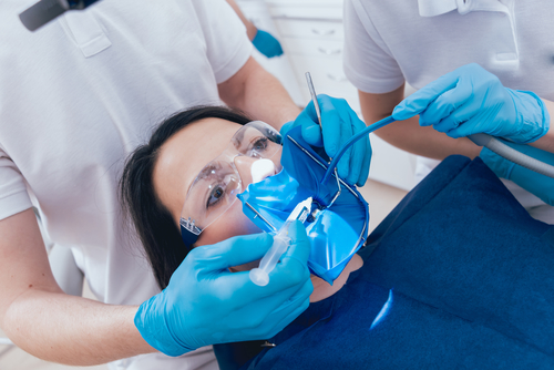 Treatment of root canals under a microscope, work with an assistant. Modern technology